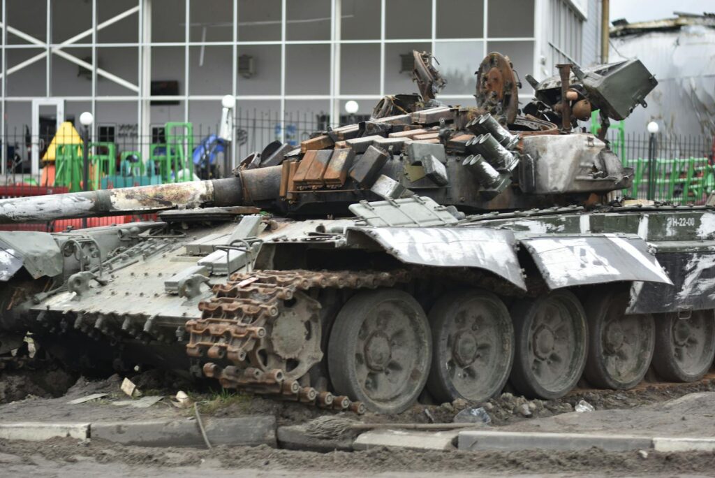 A destroyed military tank in an urban environment showcasing war damage.